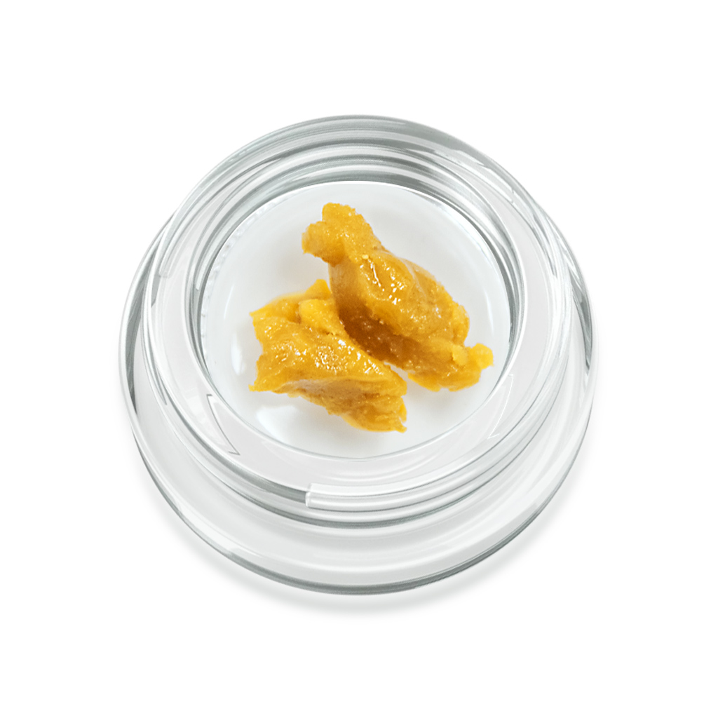 Cannabis concentrate in a glass jar on a white background